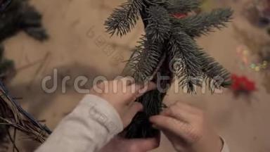 儿童和成人的手在圣诞树上<strong>缠绕树枝</strong>做花环